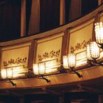 A chandelier hanging-from the ceiling of a building at the opera.